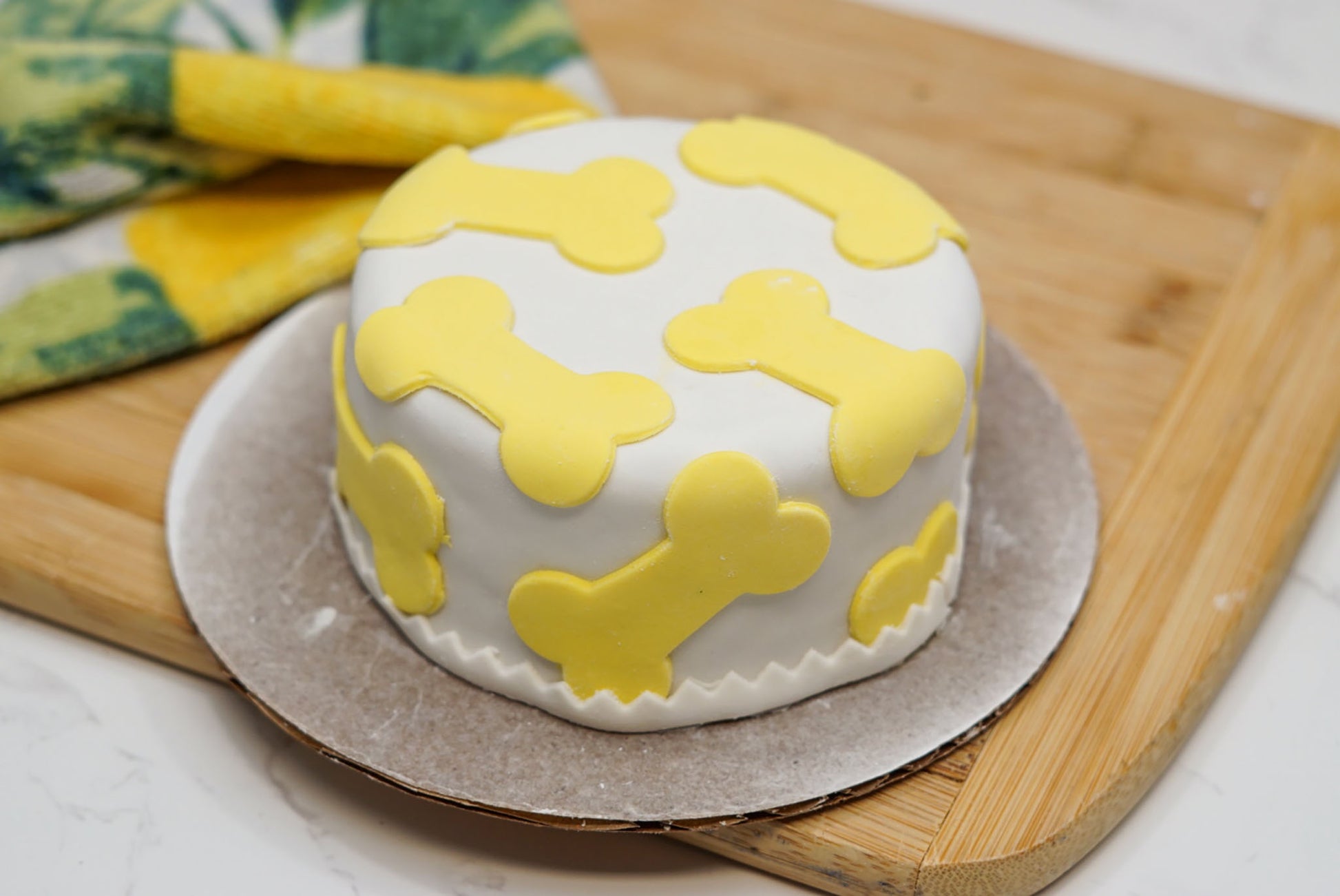 Top view of a dog birthday cake with colorful bone decorations and fondant frosting